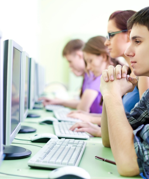 A photo a people sitting in a cybercafe using the internet